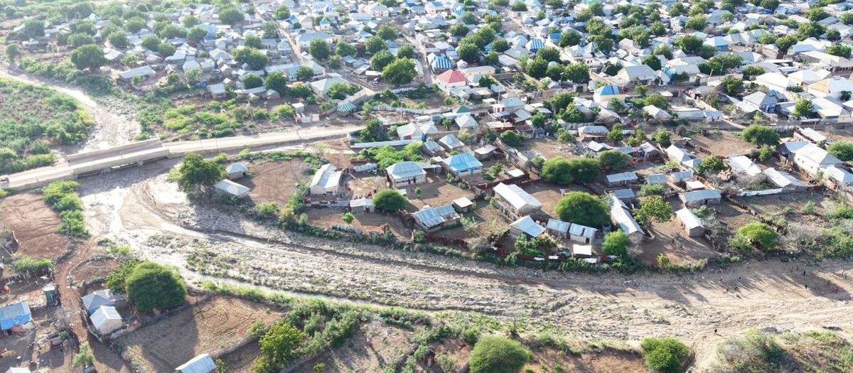 Aerial view of the silted Kurman Valley channel running between dense housing in Bardhere